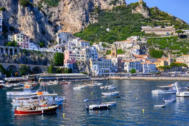 Small boats moored in the port at Amalfi, below the town and the cliffs.