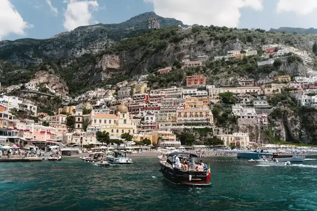 A boat arriving in Positano below the houses on the hillside.